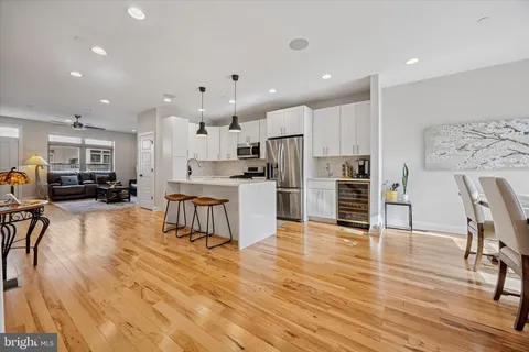 a kitchen with stainless steel appliances refrigerator oven dining table and chairs