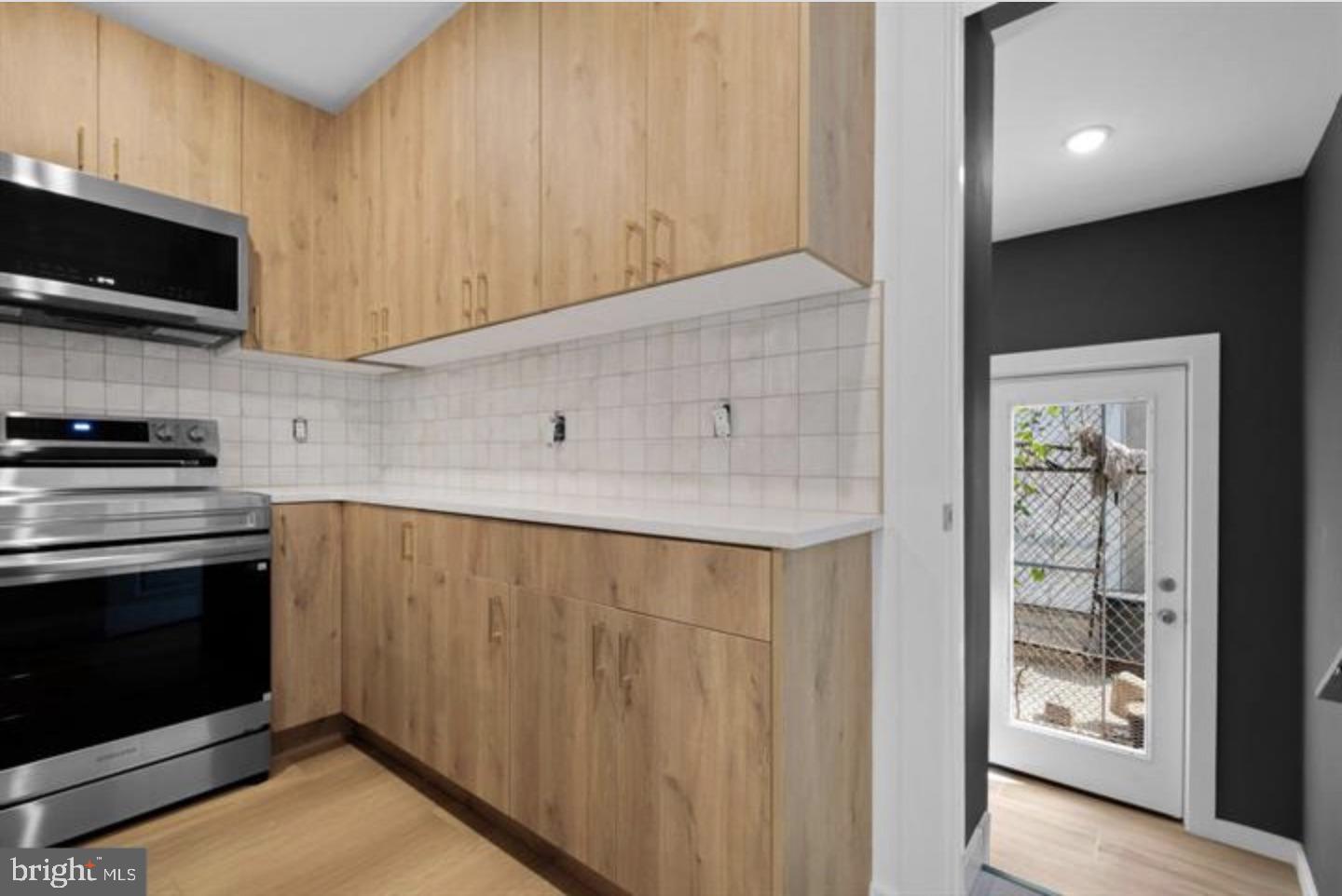 2215 Mutter Street Philadelphia, PA 19133 - Photo 9 of 21 a kitchen with stainless steel appliances a stove a microwave and cabinets
