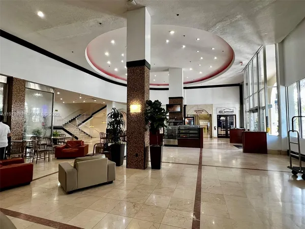 a living room with lots of furniture and lots of potted plants