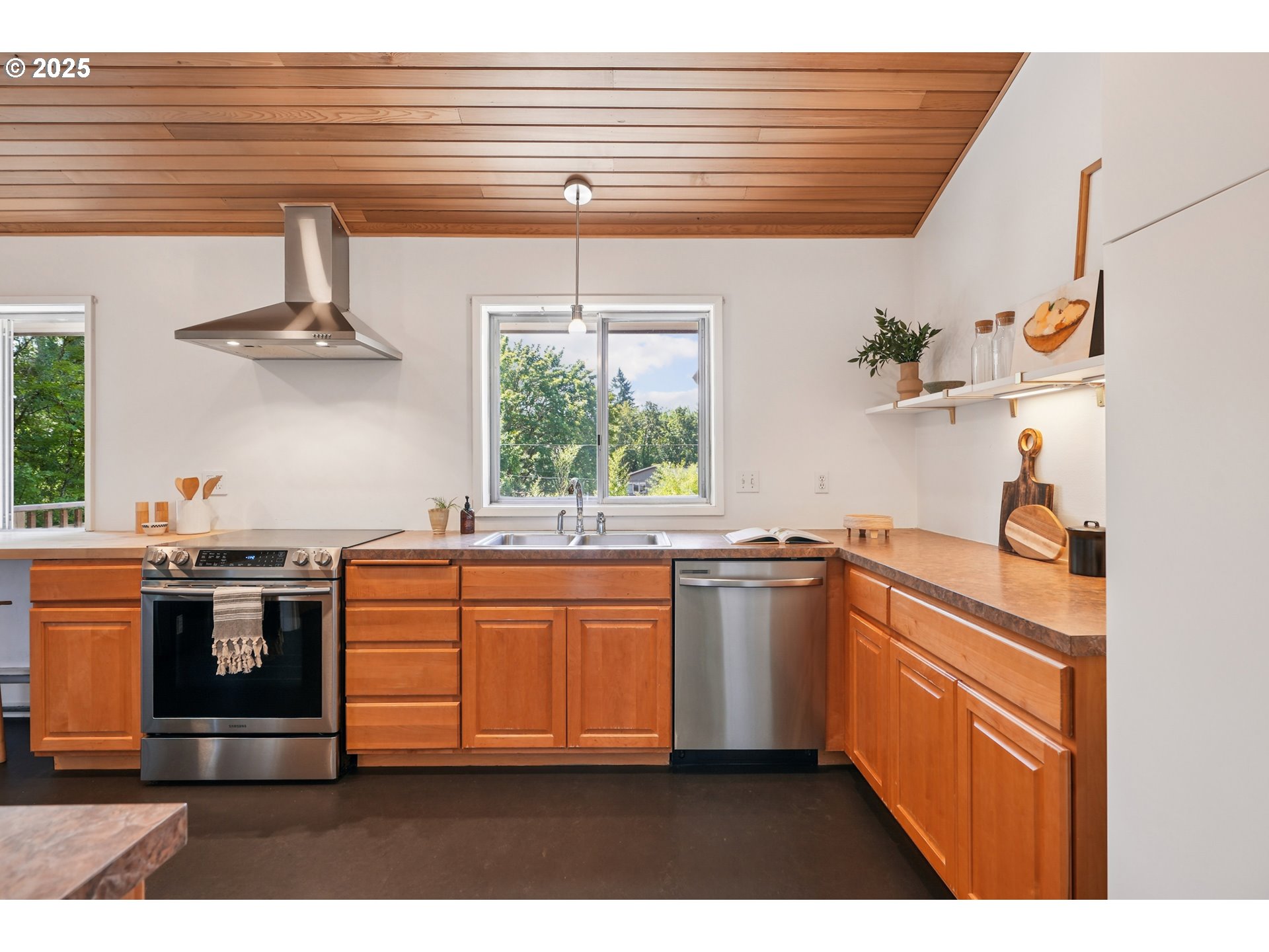 5820 Southwest Miles Court Portland, OR 97219 - Photo 13 of 48 a kitchen with stainless steel appliances granite countertop a sink window and white cabinets