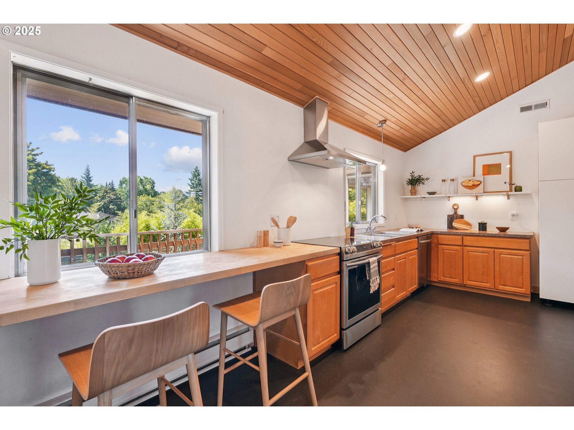 5820 Southwest Miles Court Portland, OR 97219 - Photo 16 of 48 a kitchen with stainless steel appliances kitchen island granite countertop a table chairs in it and wooden floors