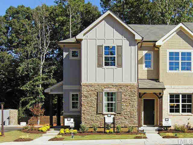 698 Wickham Ridge Road, Unit 137 Apex, NC 27539 - Photo 1 of 4 a view of a big house with plants and large tree