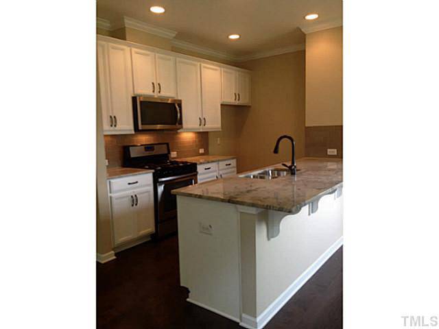 698 Wickham Ridge Road, Unit 137 Apex, NC 27539 - Photo 3 of 4 a kitchen with a sink stainless steel appliances and cabinets
