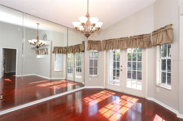 an empty room with wooden floor and window