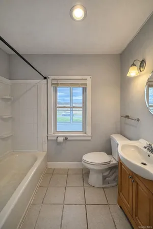a bathroom with a granite countertop sink a toilet and bathtub