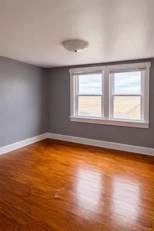 a view of a room with wooden floor and a window