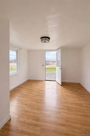 a view of empty room with wooden floor