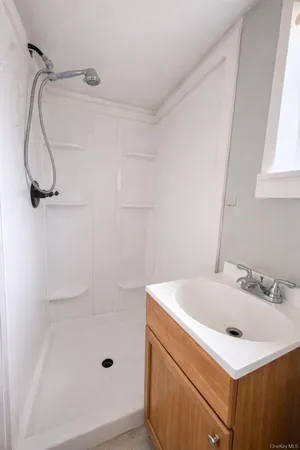 a bathroom with a sink a glass door shower and a mirror