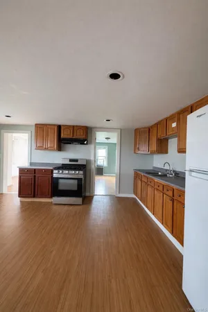 a kitchen with stainless steel appliances wooden floors and wooden cabinets