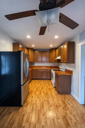 a large kitchen with stainless steel appliances granite countertop a refrigerator and a sink