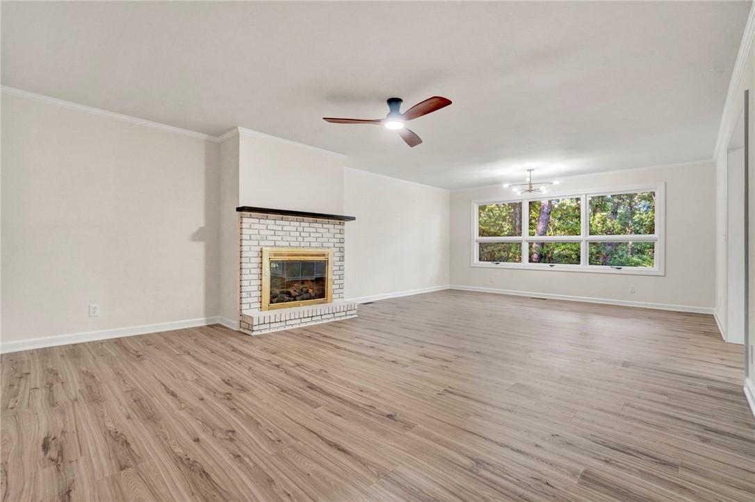 237 Earle Road Central, SC 29630 - Photo 7 of 24 A spacious living area with hardwood flooring and a classic brick fireplace, ready for cozy evenings.