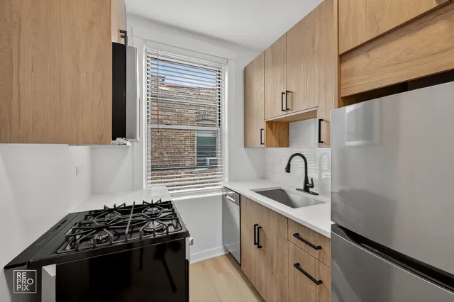 a kitchen with granite countertop a sink stove and cabinets