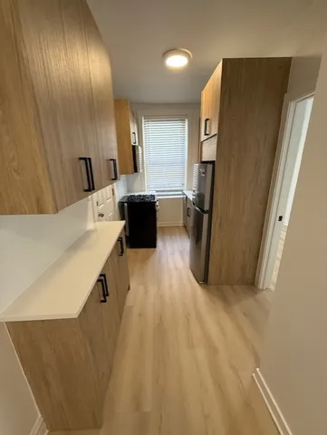 a living room with stainless steel appliances furniture a refrigerator and a sink