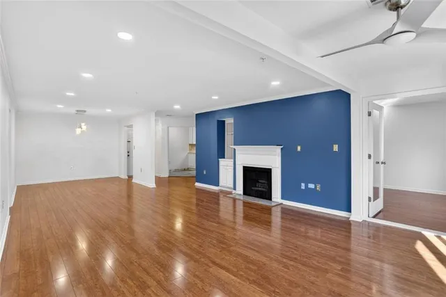 a view of empty room with wooden floor and fireplace