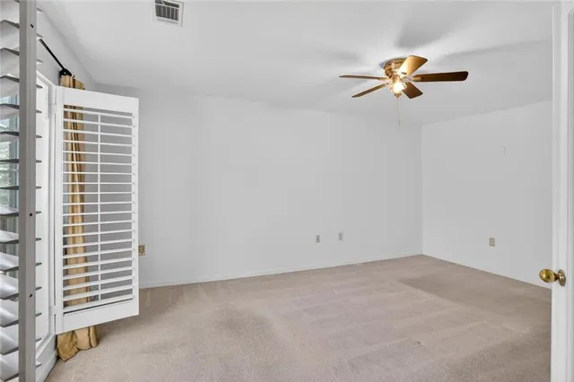 a view of empty room with window and ceiling fan