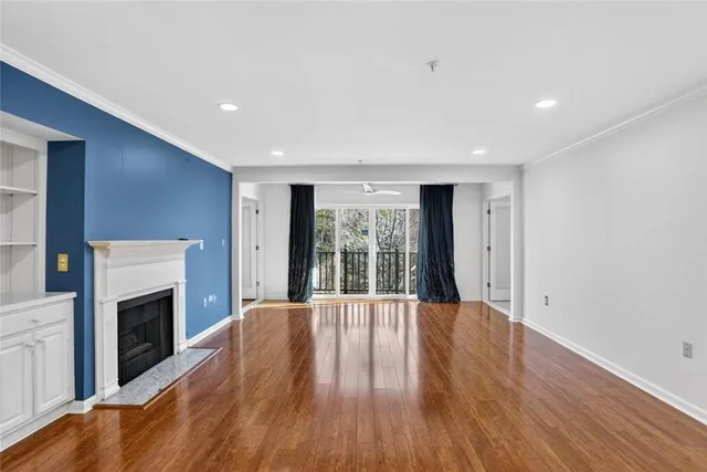 a big room with wooden floor and fireplace