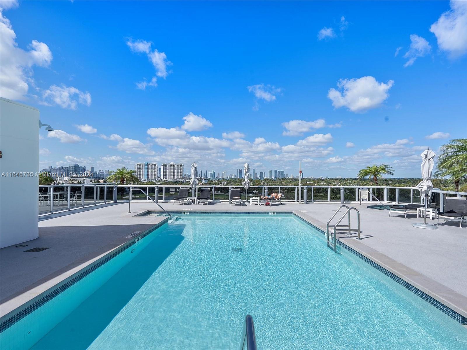 2001 Meridian Avenue, Unit 306 Miami Beach, FL 33139 - Photo 14 of 17 a view of a swimming pool and lounge chairs