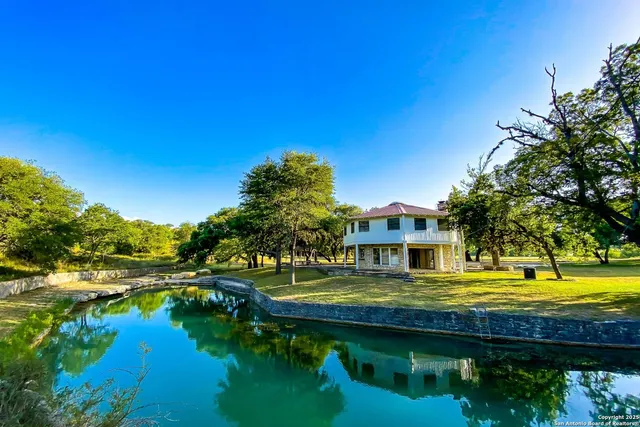 a view of a house with swimming pool next to a yard
