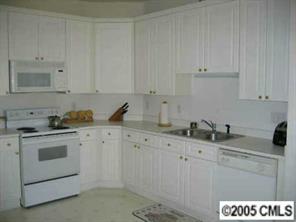 10411 Hellebore Road Charlotte, NC 28213 - Photo 6 of 8 a kitchen with granite countertop white cabinets and white appliances