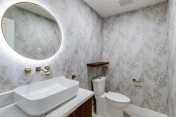 a bathroom with a sink a toilet and a mirror