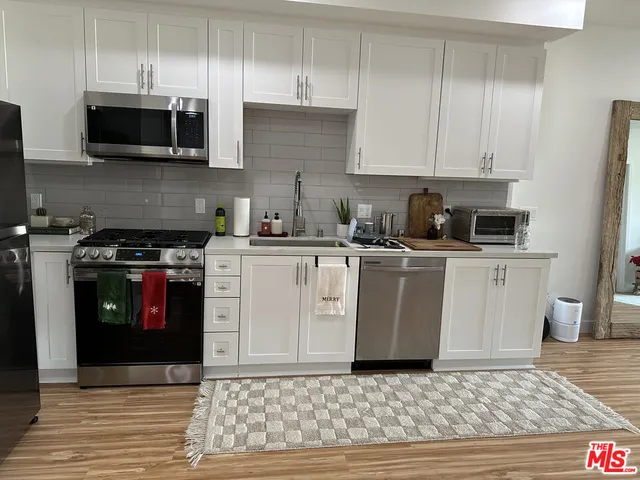 a kitchen with stainless steel appliances granite countertop a stove a sink and a microwave