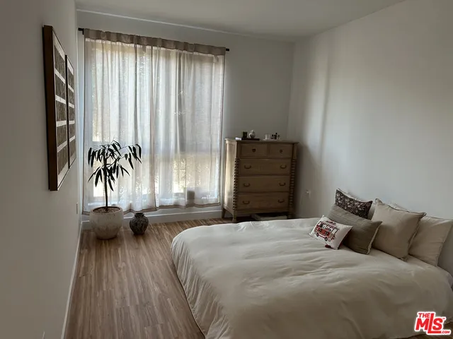 a bedroom with a bed and a large window