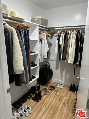 a view of walk in closet with clothes and shoes