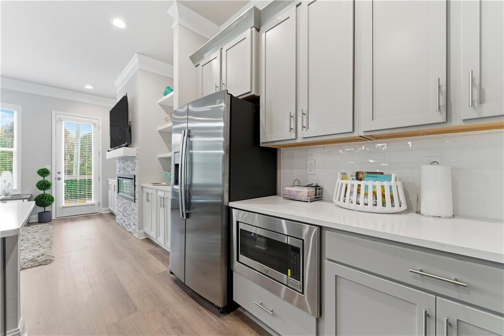 3360 Sarah Trail, Unit 1 Decatur, GA 30032 - Photo 12 of 41 a kitchen with stainless steel appliances granite countertop a refrigerator a stove and a white cabinets with wooden floor
