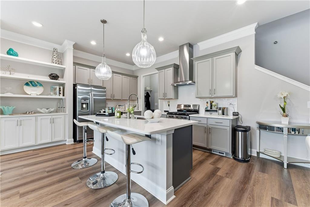 3360 Sarah Trail, Unit 1 Decatur, GA 30032 - Photo 9 of 41 a kitchen with kitchen island granite countertop a sink cabinets and wooden floor