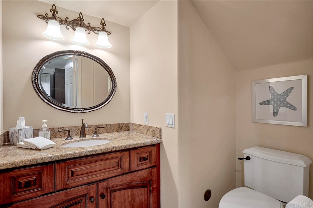 14 Camberley Laguna Niguel, CA 92677 - Photo 43 of 69 a bathroom with a granite countertop toilet a sink and a mirror