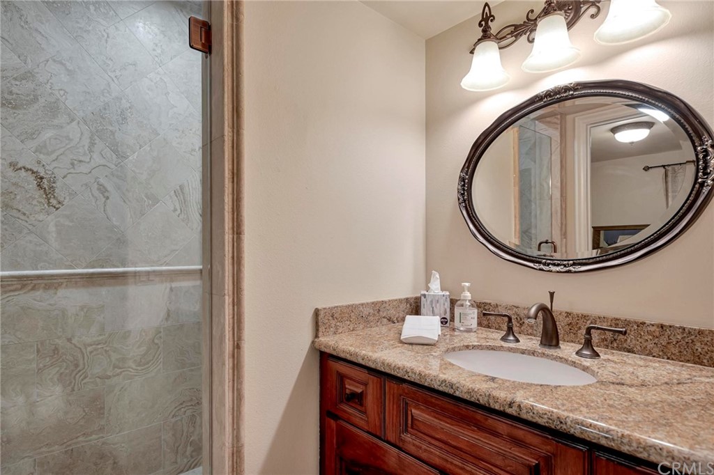 14 Camberley Laguna Niguel, CA 92677 - Photo 44 of 69 a bathroom with a granite countertop sink and a mirror