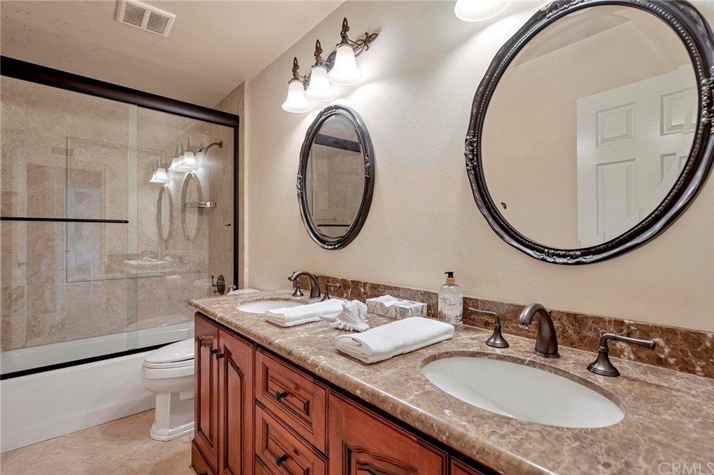 14 Camberley Laguna Niguel, CA 92677 - Photo 68 of 69 a bathroom with a granite countertop double vanity sink and a mirror