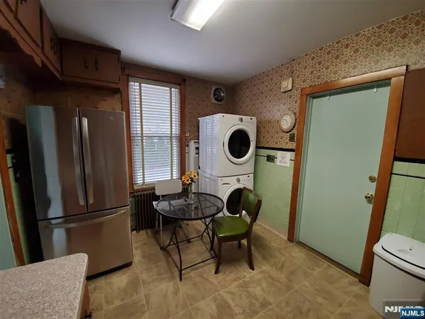 a kitchen with a refrigerator a stove top oven a clock and a window