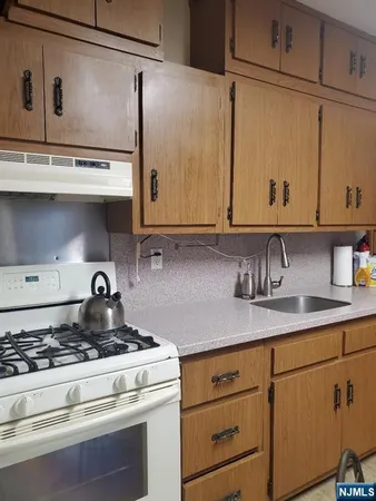 a kitchen with granite countertop a stove and a sink