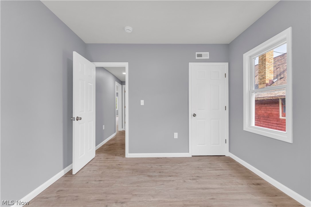 3925 Riverside Avenue Cleveland, OH 44109 - Photo 33 of 46 Wood-finish flooring, light gray wall color, white trim, and a white paneled door