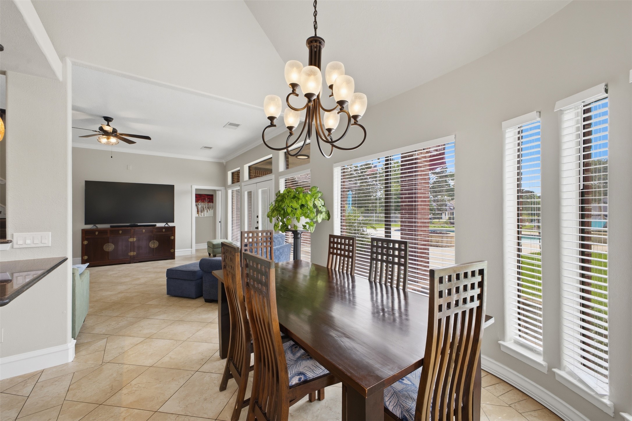 12710 Aries Loop Willis, TX 77318 - Photo 10 of 40 The dining area features a dark wood dining table, a chandelier, and multiple windows with blinds