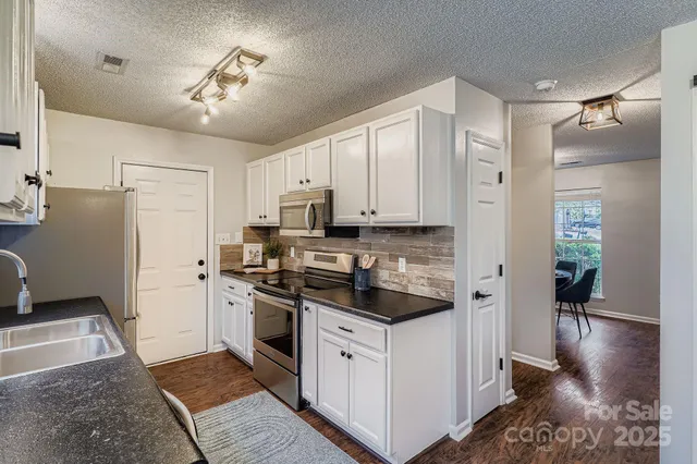 a kitchen with a refrigerator and a stove top oven
