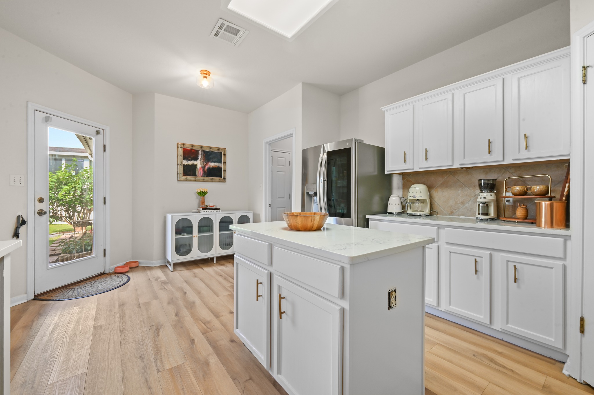 5888 Fergus Kyle, TX 78640 - Photo 10 of 40 A well-lit kitchen with sleek white cabinetry, a functional island, and contemporary stainless steel appliances.