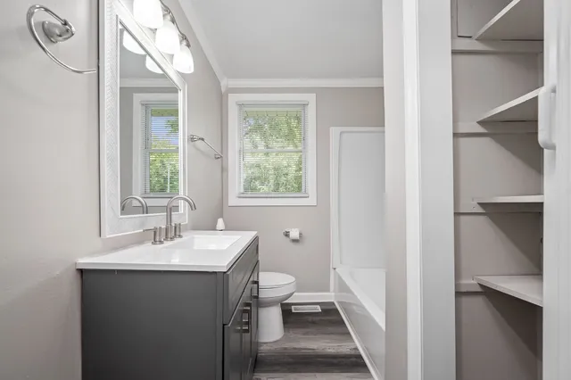 a bathroom with a sink a toilet and a window