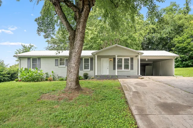 a front view of a house with a yard and potted plants