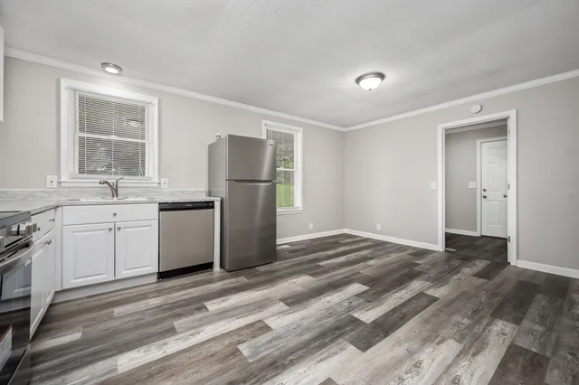 a kitchen with a sink a refrigerator and cabinets
