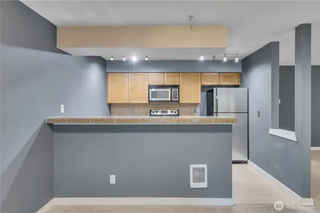 a view of kitchen with stainless steel appliances granite countertop refrigerator sink and stove