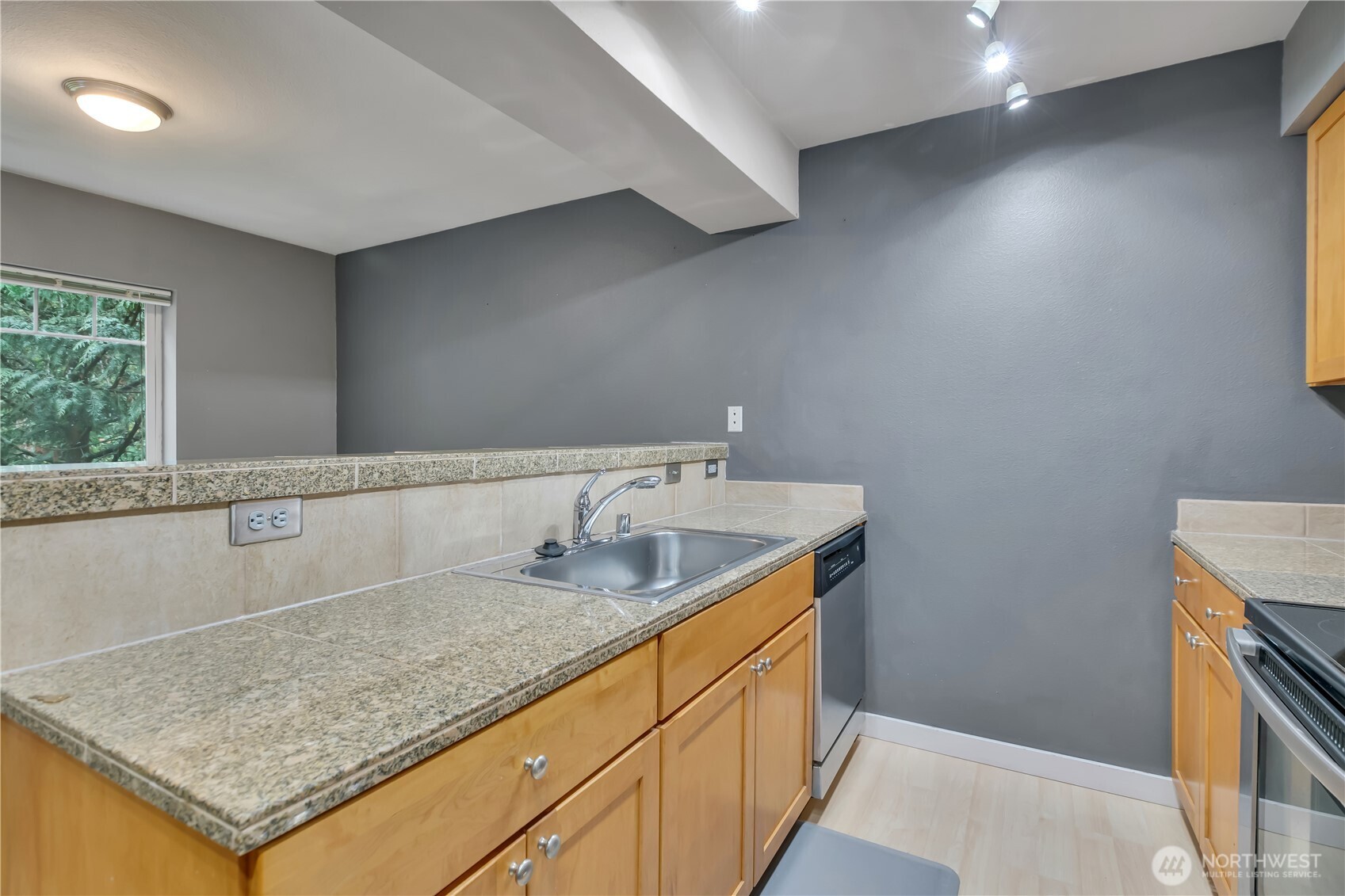 18930 Bothell Everett Highway, Unit B304 Bothell, WA 98012 - Photo 15 of 35 a bathroom with a granite countertop sink and a mirror