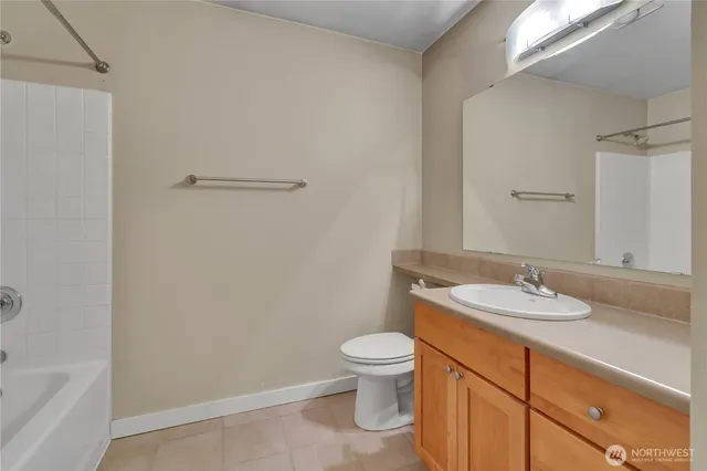a bathroom with a granite countertop sink a toilet and a bathtub