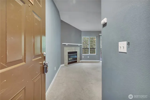 a view of an empty room with a fireplace and a window