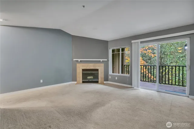 a view of an empty room with a fireplace and a window