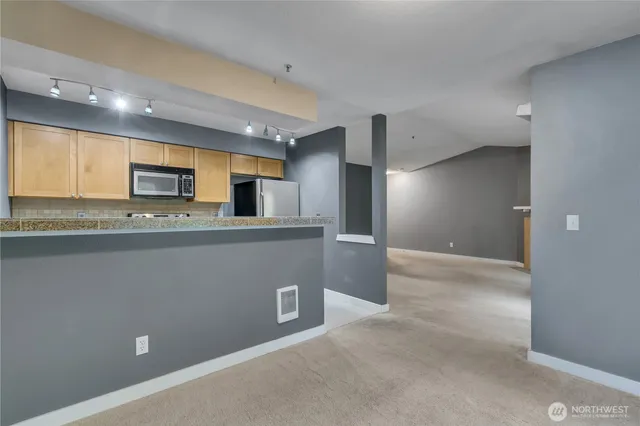 a view of a kitchen with a sink and a refrigerator