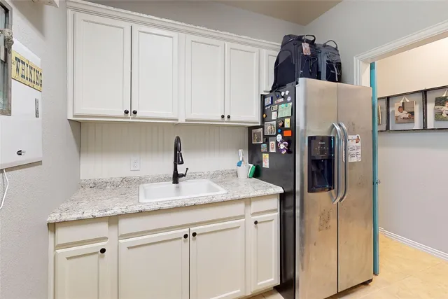 a kitchen with stainless steel appliances granite countertop a refrigerator and a sink