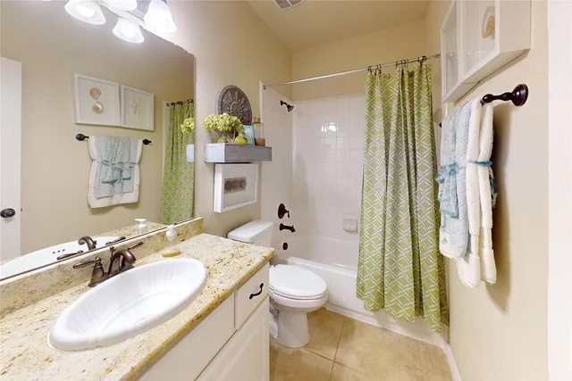 a bathroom with a granite countertop sink a toilet and shower