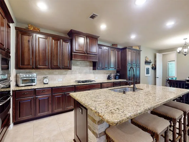a kitchen with kitchen island granite countertop wooden cabinets a sink and dishwasher